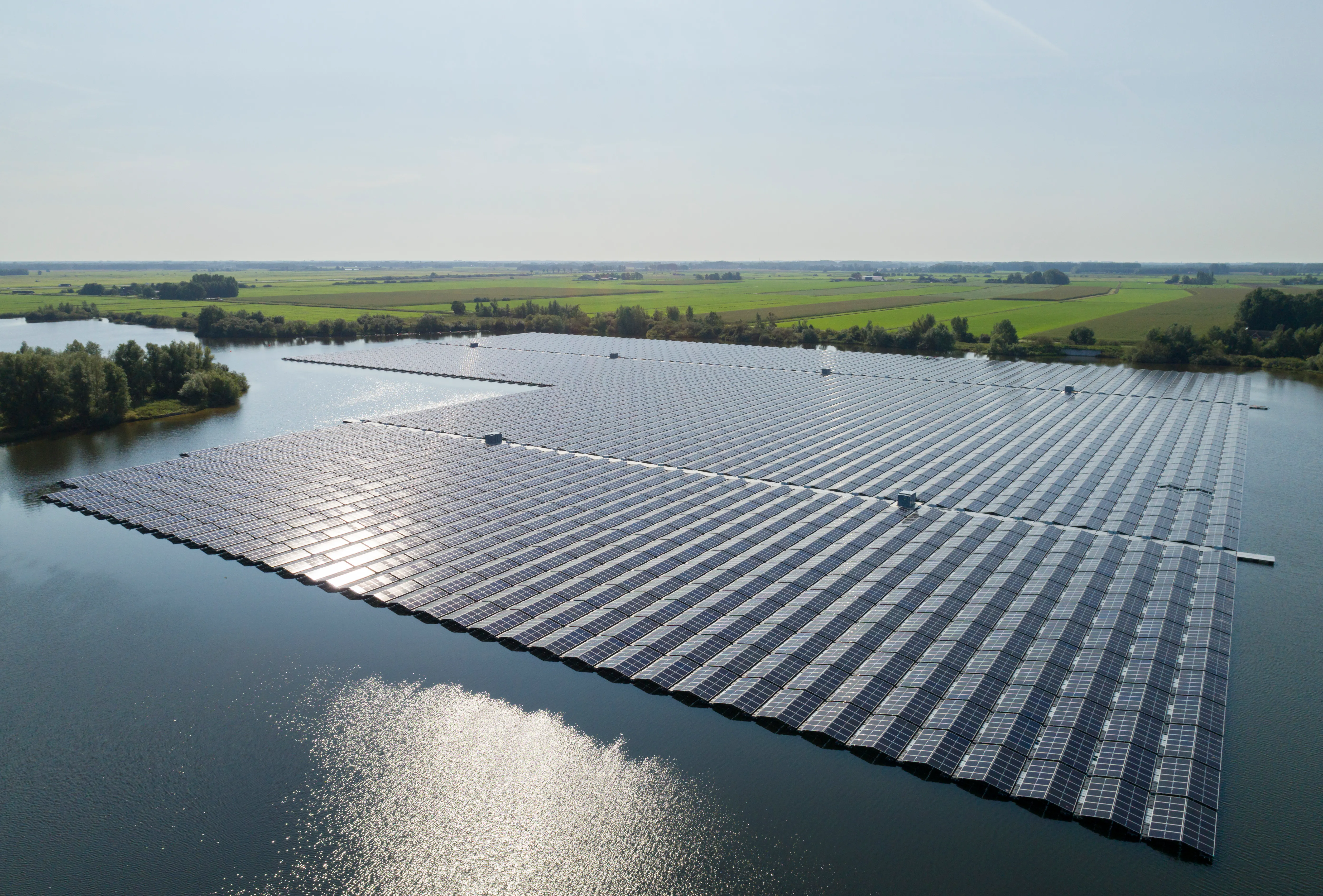 Rows of floating photovoltaic panels moored on the surface of a reservoir
